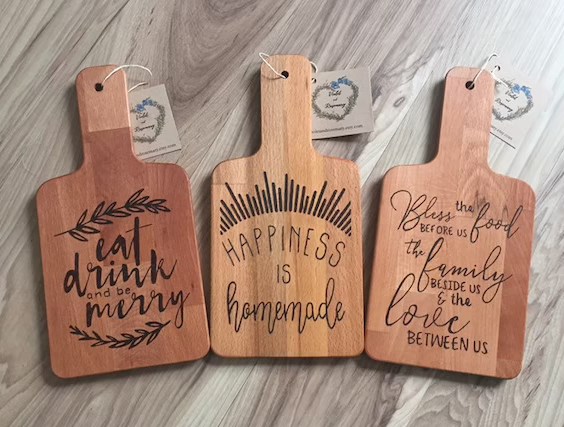 three small wooden cutting boards with different sentimental sayins burnt into them