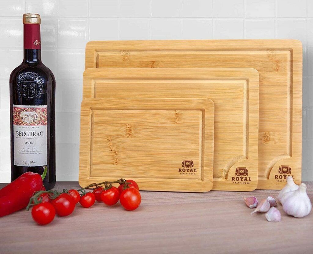 trio of bamboo cutting boards on counter next to bottle of wine