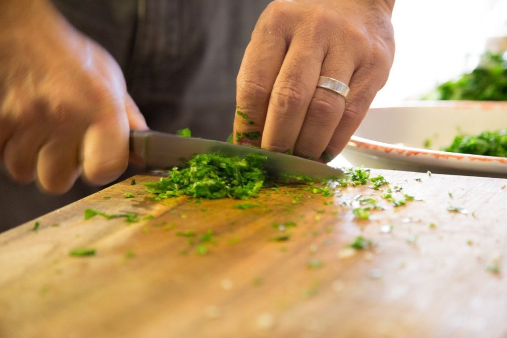 up close of someone chopping herbs on cutting board