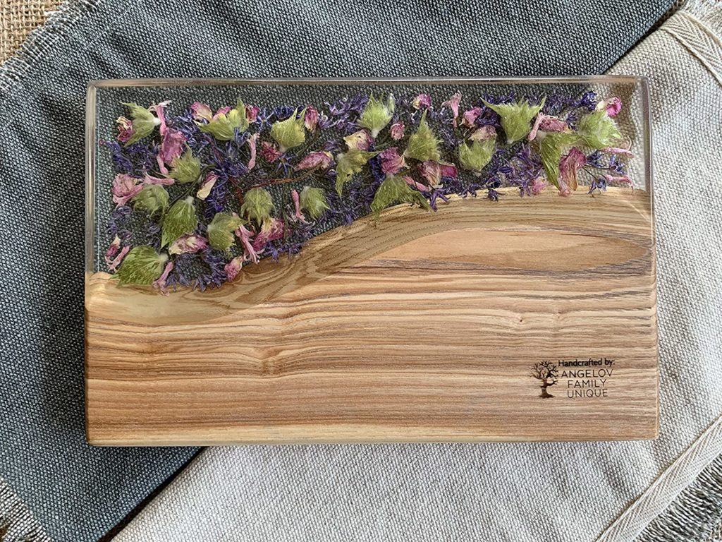 wooden cutting board with clear resin and pressed purple flowers