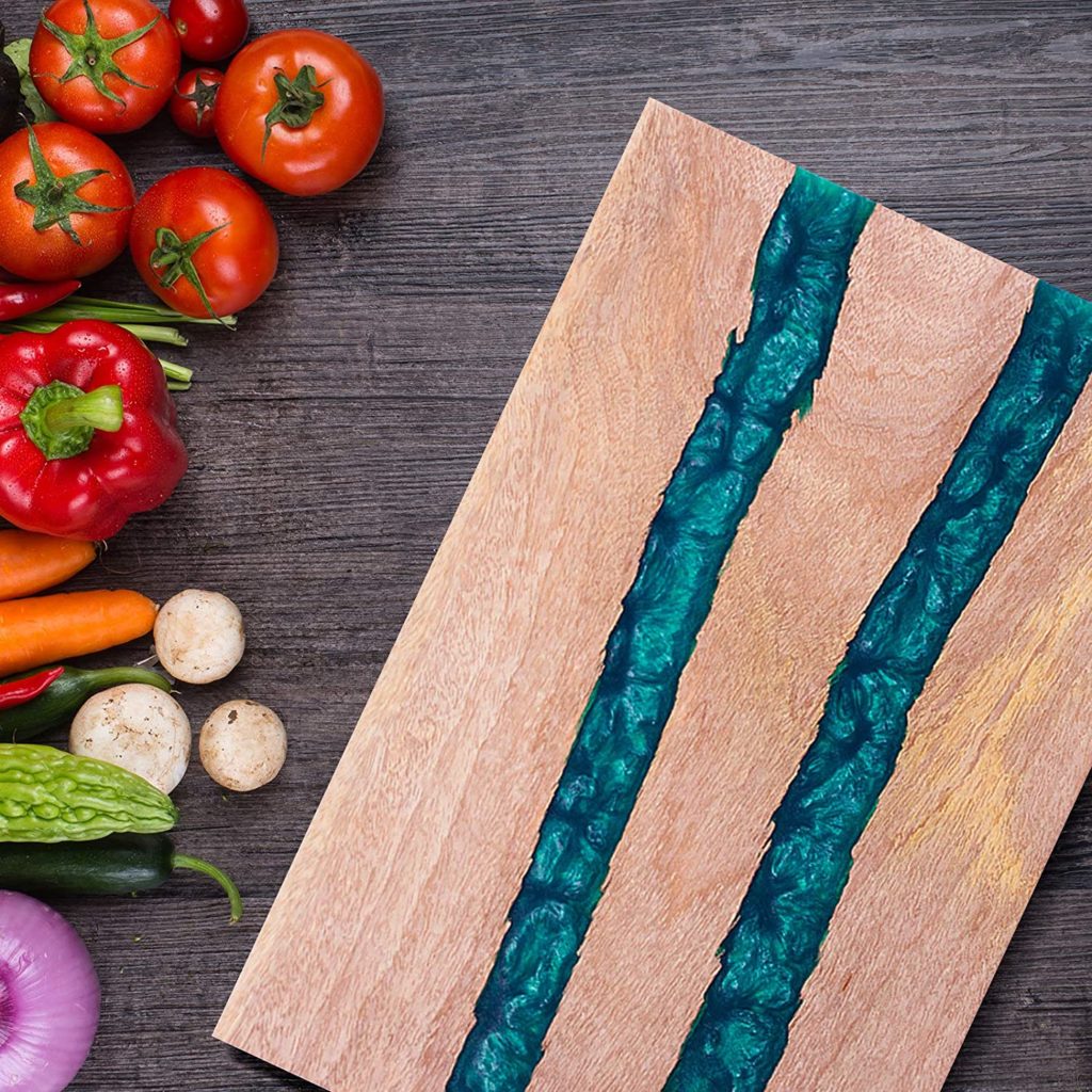 wooden cutting board with two blue resin stripes next to produce