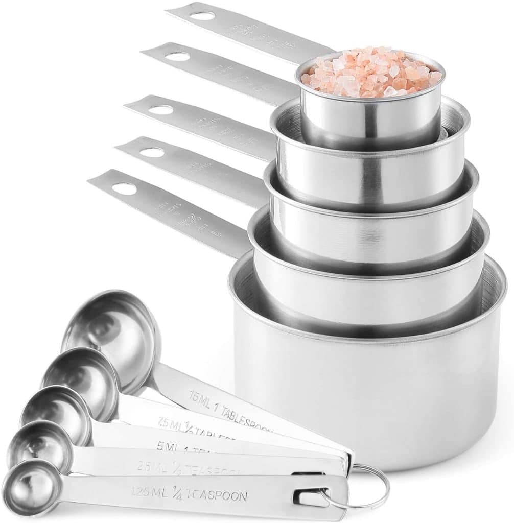 stackable stainless steel measuring cups and spoons filled with pink salt
